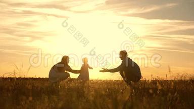 <strong>爸爸妈妈</strong>和孩子在公园里玩日落，孩子迈出第一步。 幸福的家庭玩他们的女儿